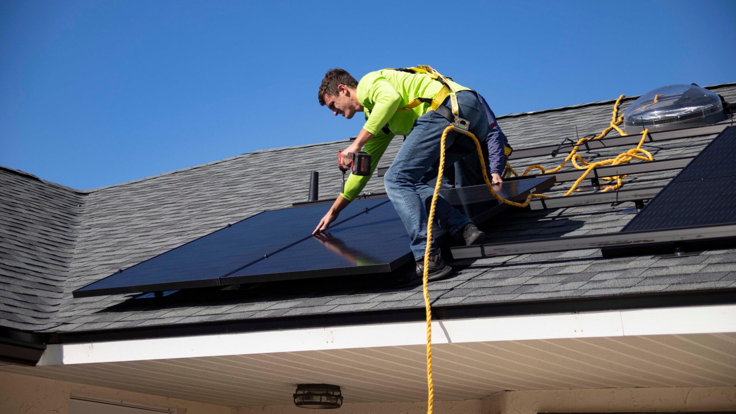 Worker on house installing solar